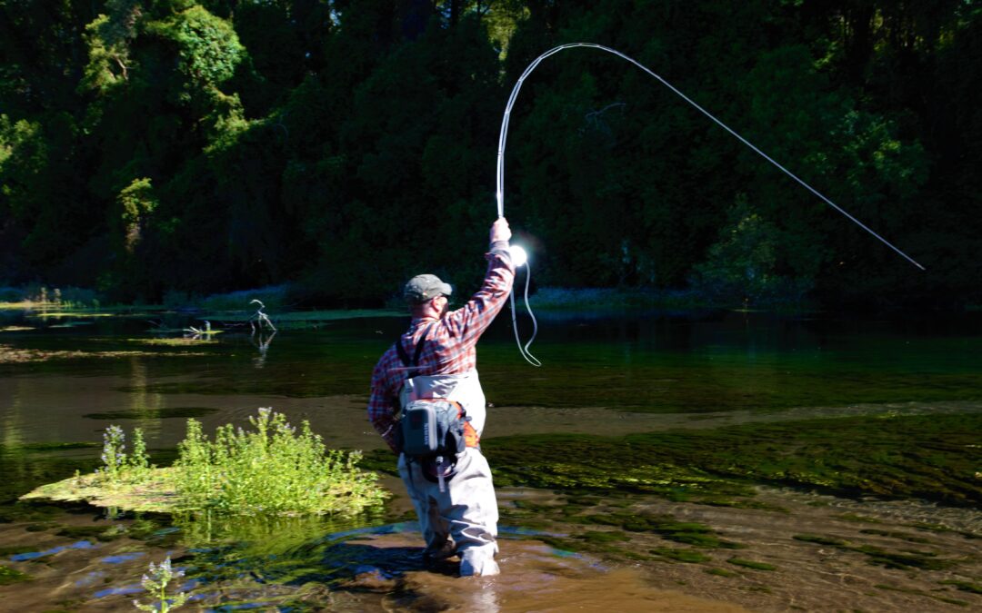 Hombre pescando con caña en un río.